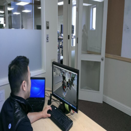 Roblox employee inside their office with a monitor showing the same office virtually